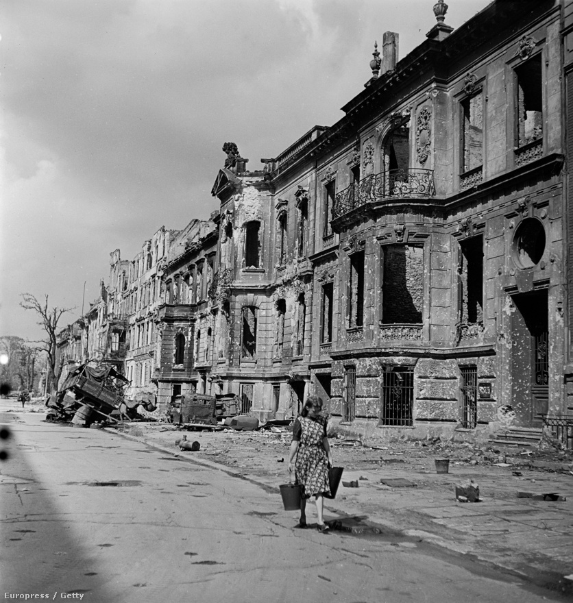 Vizet hord egy berlini lány a város egyik lerombolt utcáján.