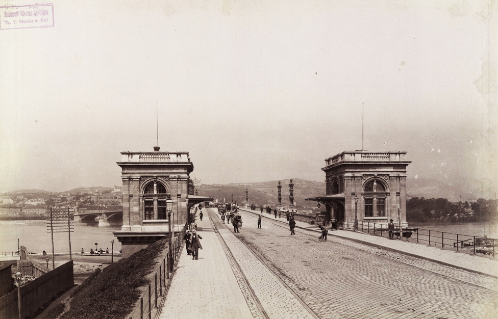 A Margit híd pesti hídfője a vámházakkal, 1896-ban. A túloldalt, a budai hídfő felett a Gül Baba türbéje köré épített Wagner villa is felsejlik.