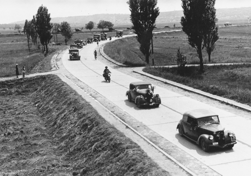 A fenti képen 1942-ben, Érd mellett koptatja a balatoni műutat a Magyar Királyi Haditudósító század menetoszlopa. Ha pár évvel korábban ugyanitt lefotózták volna ezt a ritkaságszámba menő kocsisort, a járművek nem az úttest jobb oldalán, hanem a balon haladtak volna - a jobboldali közlekedést ugyanis az 1941. június 26-án kiadott 187 000/1941-es BM rendelet rögzítette. Igaz, a hazai németbarát újságok már jóval korábban követelték változtatást, mivel Ausztriában 1938. szeptember 19-től, Csehszlovákiában pedig 1939 május 1-től tértek át a jobboldali közlekedésre, a korabeli média hangadói pedig az idegenforgalom visszaesésével riogatták az olvasókat, amennyiben nem változtatjuk meg a hajtási irányt.