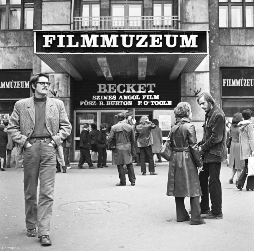 A Károly körút és Dohány utca sarkán, a mai Belvárosi Színház helyén működött évtizedeken át a hallatlanul népszerű Filmmúzeum nevű mozi, ahol sok filmet játszottak, igen kevésszer. Afféle szelep volt ez, minőségi programmal. Itt nem voltak kötelező szovjet, bolgár és NDK-beli filmek, csak a filmművészet java – egyáltalán nem csak régi filmek. Olyan népszerű volt, hogy mindig volt jegyüzér is. (A fiatalok kedvéért: olyan személy, aki előre felvásárolt jegyeket, és azt nagy felárral adta tovább.) Talán a háttal álló férfi? Akkoriban a legújabb filmek 1-2 évvel követték a világpremiert. Valakik abban is döntöttek, hogy ez és ez a film jöhet Magyarországra, de csak a Filmmúzeum programja keretében.