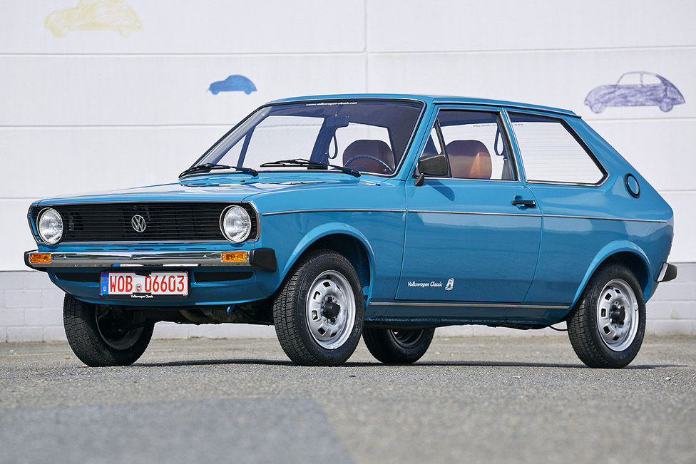 Az első, 1975-ben bemutatott Polo, teljes vézna bájában. Annyira nem Volkswagen, hogy a benne levő motort nem is látta tervezőasztalon VW-mérnök, az 50 db próbaautó darabonkénti 100 ezer kilométeres nyúzópróbája is mind Audikkal zajlott, sőt, a VW-verziónak nem is volt saját gyári kódja, az ugyanaz, mint az Audi 50-é: Typ 86. A bölcsőkor körüli zavarok ellenére a kortársakhoz képest jobb minőségűnek, nagyautósabban kialakítottnak és kulturáltabbnak tartott Polo zajos siker lett, az Audi bukás.