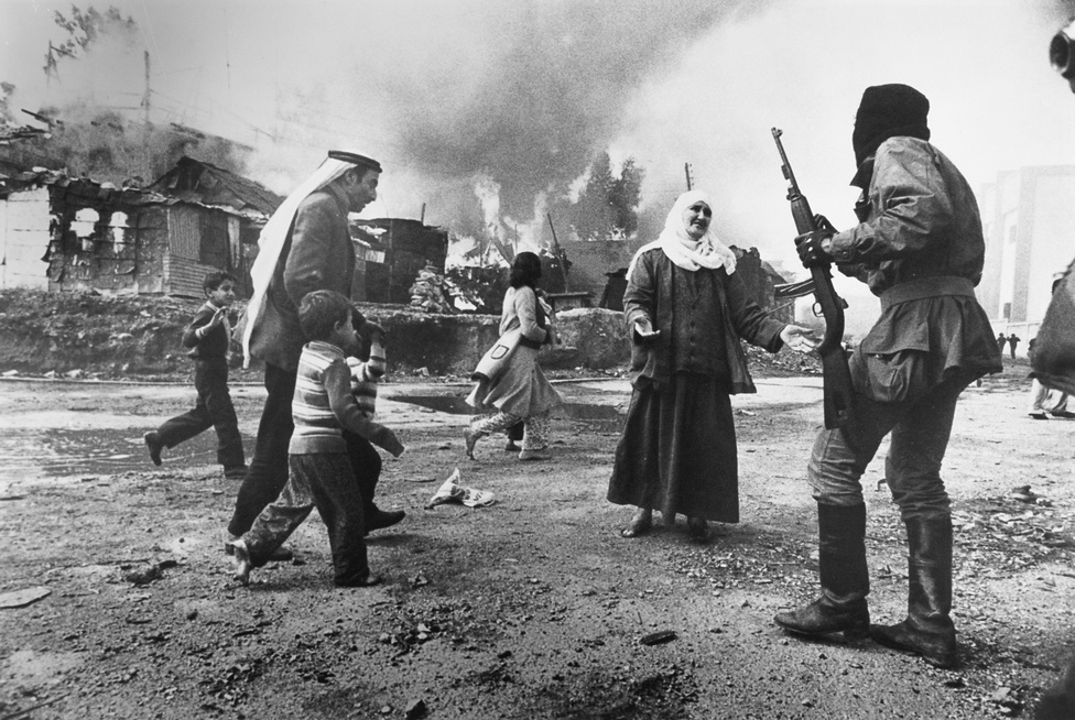 1977. Bejrút, Libanon. Palesztin nő könyörög egy falangista fegyveresnek a kelet-bejrúti Karantina városrészben.Aznap reggel a falangisták megtámadták és elűzték a városrész zömmel palesztin menekült lakóit, otthonukat felgyújtották, több száz embert megöltek. A karantinai mészárlás volt az egyik első erőszakos esemény a libanoni polgárháború kezdetén. A francia Françoise Demulder, az esemény szemtanúja az első női fotográfus volt, aki elnyerte Az év fotója díjat a könyörgő palesztin asszony megrendítő fotójával.